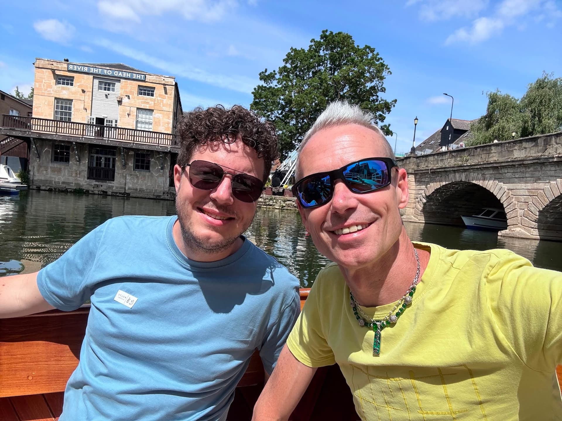 Friends smile for a selfie while punting on the river.